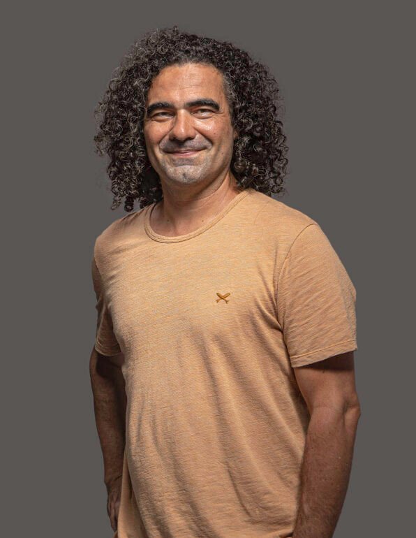 pedro ogava sorrindo em um ambiente de fundo cinza